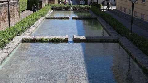 Cascading Rectangular Fountain Surrounded by Hedges and Stones Stockbeeldmateriaal 300287301