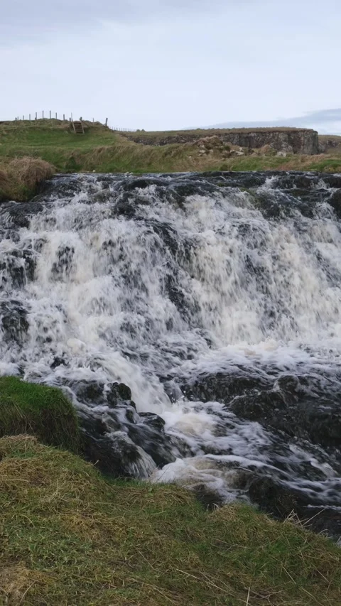 Cascading river water over black rocks Dunseverick Waterfall Stock-Footage 303450787