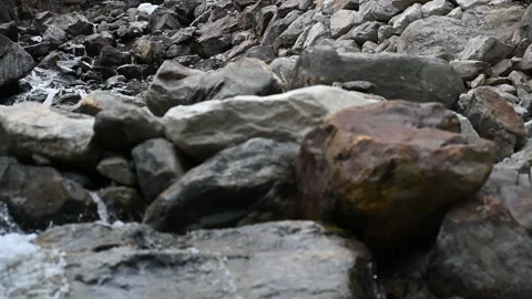 Cascading rocky mountain stream blocked by rocky damn camera tilt down Video stock 234730897