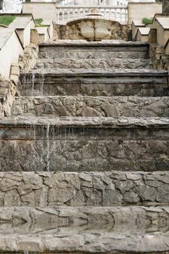 Cascading stone steps with flowing water in a classic garden setting Stock Photos