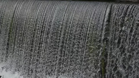 Cascading Water Creates Foamy Pool Scene, Industrial River Scene Showcases Stock Footage 323777178