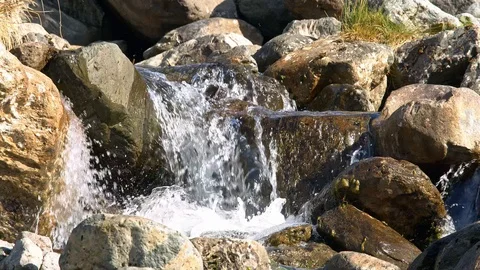 Cascading water fall over rocks in lake land mountain scene. Slow motion. Stock Footage 118467581