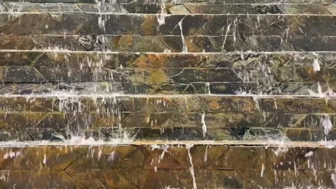 Cascading water flow on a decorative wall made of natural stone 動画素材 341068336