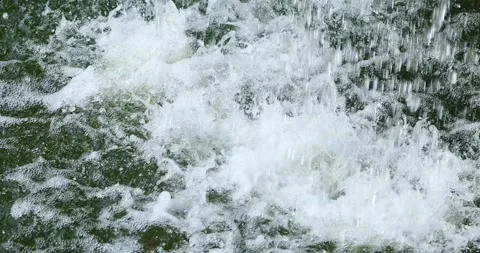 Cascading water splashing into a pool, creating bubbles and dynamic motion... Stock Footage 338430384