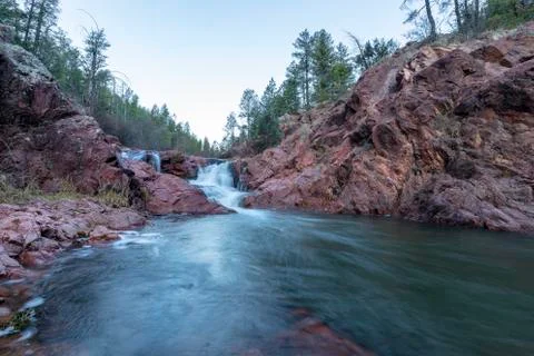 Cascading waterfall among the pine trees Stock Photos