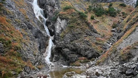 A cascading waterfall in autumn setting 스톡 동영상 260847276