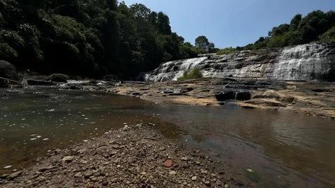 Cascading Waterfall Flowing Over Rocks, Lush Forest, Sunny Day, Low Angle Tracki Stock Footage 324771216