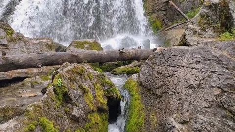 Cascading waterfall in mountains. Stream of water between gray mossy boulders. Stock Footage 166248806
