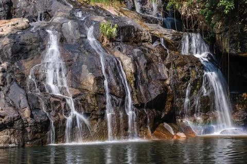 Cascading Waterfall Over Dark Rocks Photos
