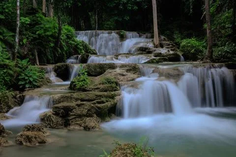 Cascading Waterfall Tiers Flow Through Lush Tropical Rainforest Wide Shot Stock Photos