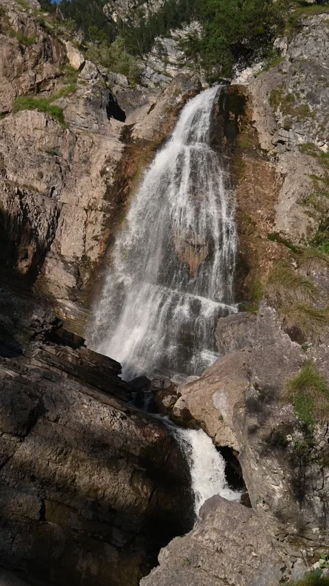 Cascading waterfalls in the evening sun, vertical shot Video stock 260871197