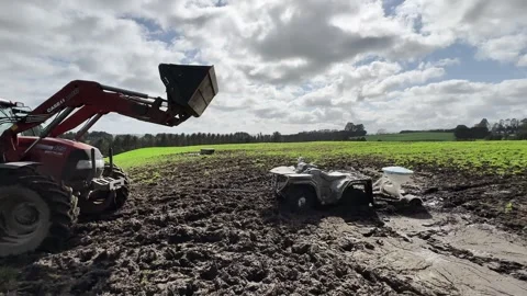 Case IH tractor pulling buggy from muddy field Stock Footage 305549766