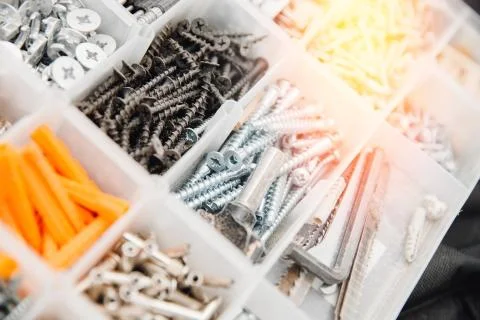 Case with small construction objects. Set metal tool box of screws, anchors Stock Photos