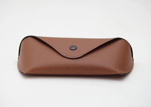 Case for storing glasses, brown, with a button, on an isolated white background Stock Photos