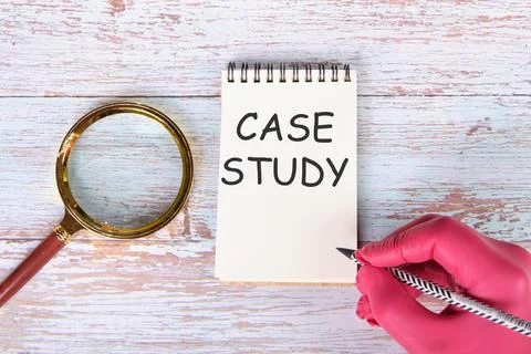 Case study I am writing on a notebook lying on old boards next to a magnifyin Stock Photos