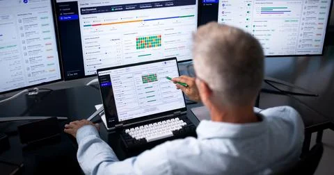 Caseworker Using Laptop To Track Client Benefits In Public Office. Stock Photos