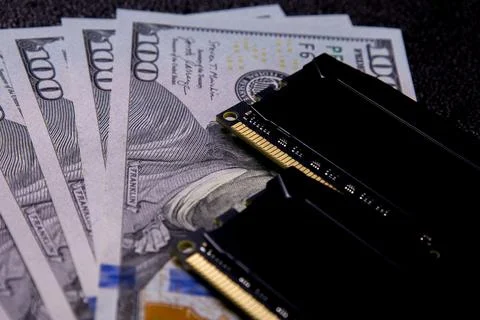 Cash and computer memory modules arranged on a surface showing financial Stock Photos