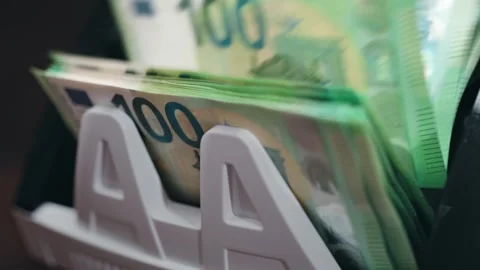 Cash counting machine displaying stacks of 100 euro banknotes in a continuous Stock Footage 331080392