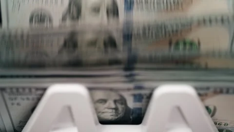 Cash counting machine processes stacks of hundred-dollar bills, showcasing the Stock Footage 331079878