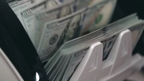 Cash counting machine processes stacks of U.S. dollar bills, showcasing the Stock Footage 333979126