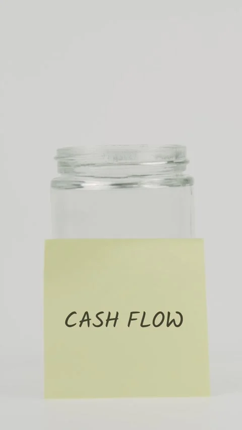 Cash flow text or word on yellow sticky note attached to glass jar with hand Stock Footage 311689292