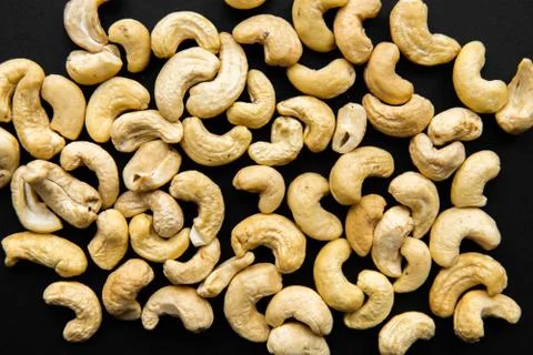 Cashew nuts scattered on a black table. Cashew nut is a healthy vegetarian Stock Photos