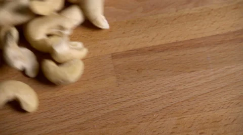 Cashew nuts spill onto table in slow motion Stock Footage 61690772