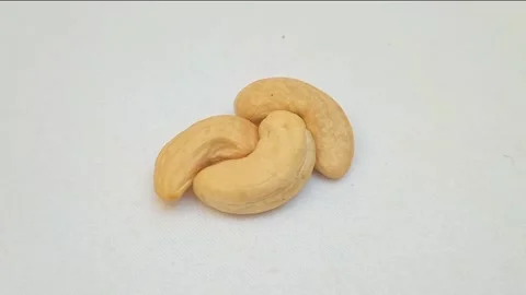 Cashew nuts on a turntable on white background. Macro shot. rotating Stock Footage 275591503