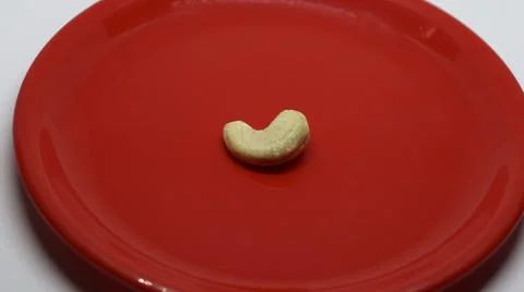 An cashew nuts is on a white background on a red plate Stock Photos