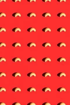 Cashew pattern on red background, colorful flat lay food texture top view Stock Photos