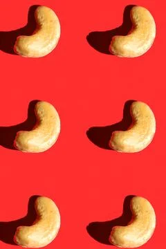 Cashew pattern on red background, colorful flat lay food texture top view Stock Photos