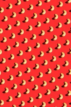 Cashew pattern on red background, colorful flat lay food texture top view Stock Photos