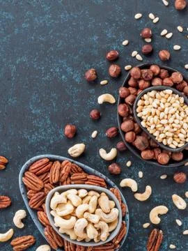 Cashew, pecan, pine nuts, hazelnuts on blue Foto stock
