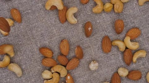 Cashews, almonds and hazelnuts falling down on a linen fabric. Slow motion. Stock Footage 105283185