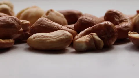 Cashews and hazelnuts lie on a white background. Moving camera to the side. Stock Footage 164880646