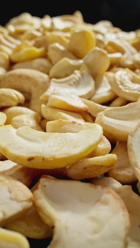 Cashews falling on pile. Group of peeled cashews. Camera slide with macro lens. Stock Footage 293159462