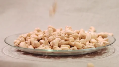 Cashews nuts falling down into glass bowl Stock Footage 72118229