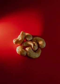 Cashews nuts without shell on red background macro Stock Photos