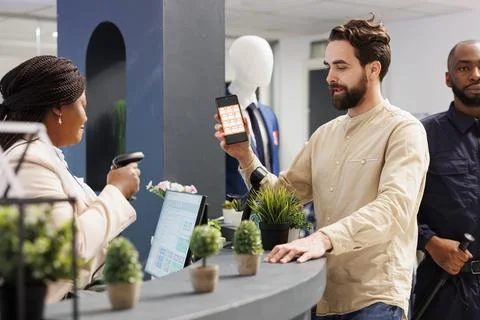 Cashier scanning mobile coupon code Stock Photos