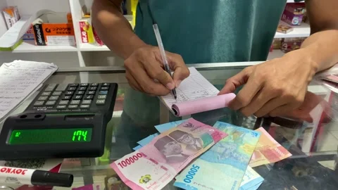 Cashier Using Calculator and Writing Sales Receipt 库存影片 335499346