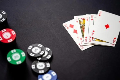 Casino chips and playing cards on minimalistic black background. Royal flash. Stock Photos