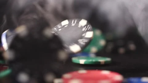 Casino chips falling as the winnings keep rolling in isolated on black smoke Video stock 205535673