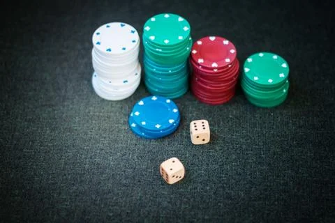 Casino poker chips stack dice on green felt background. Stock Photos