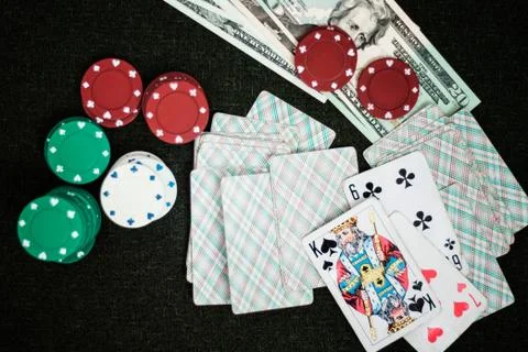 Casino poker chips stack with playing cards, dice and money on green felt bac Stock Photos