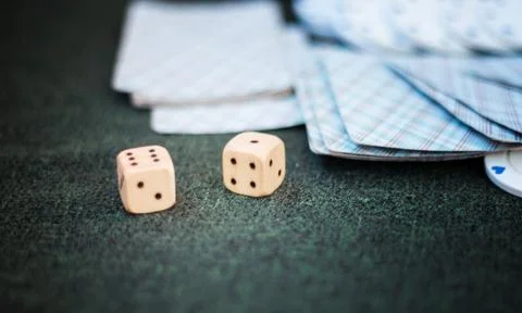 Casino poker chips stack with playing cards, dice and money on green felt bac Stock Photos