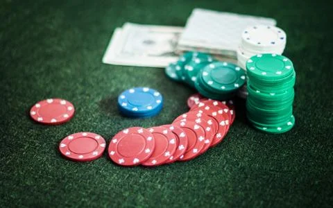 Casino poker chips stack with playing cards, dice and money on green felt bac Stock Photos