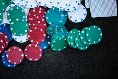 Casino poker chips stack with playing cards, dice and money on green felt bac Stock Photos