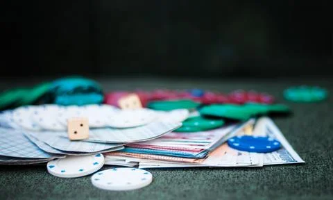 Casino poker chips stack with playing cards, dice and money on green felt bac Stock Photos