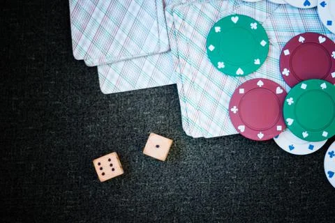 Casino poker chips stack with playing cards, dice and money on green felt bac Stock Photos