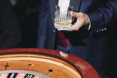 Casino table with roulette wheel in motion, with casino chips, tokens, the .. Stock Photos